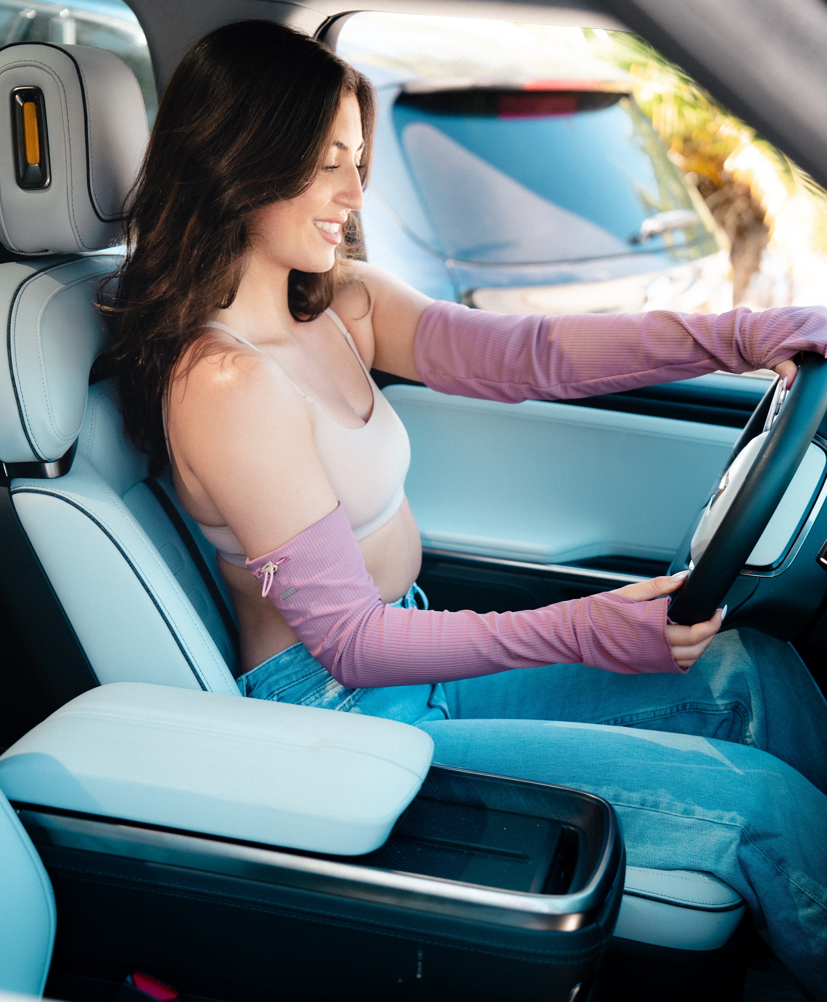 Woman sitting inside a car with a light blue interior