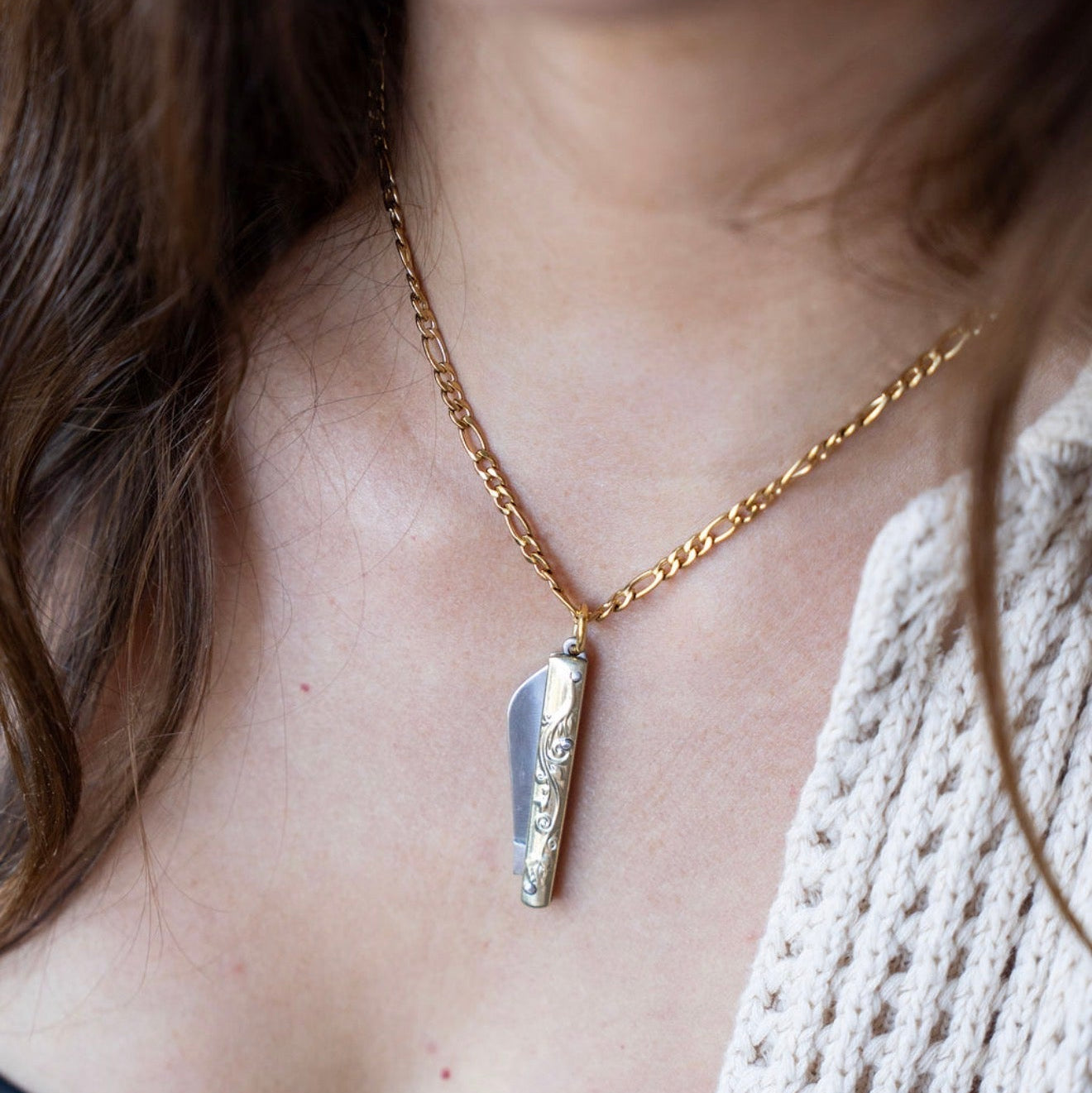 Necklace with a knife pendant worn by a person