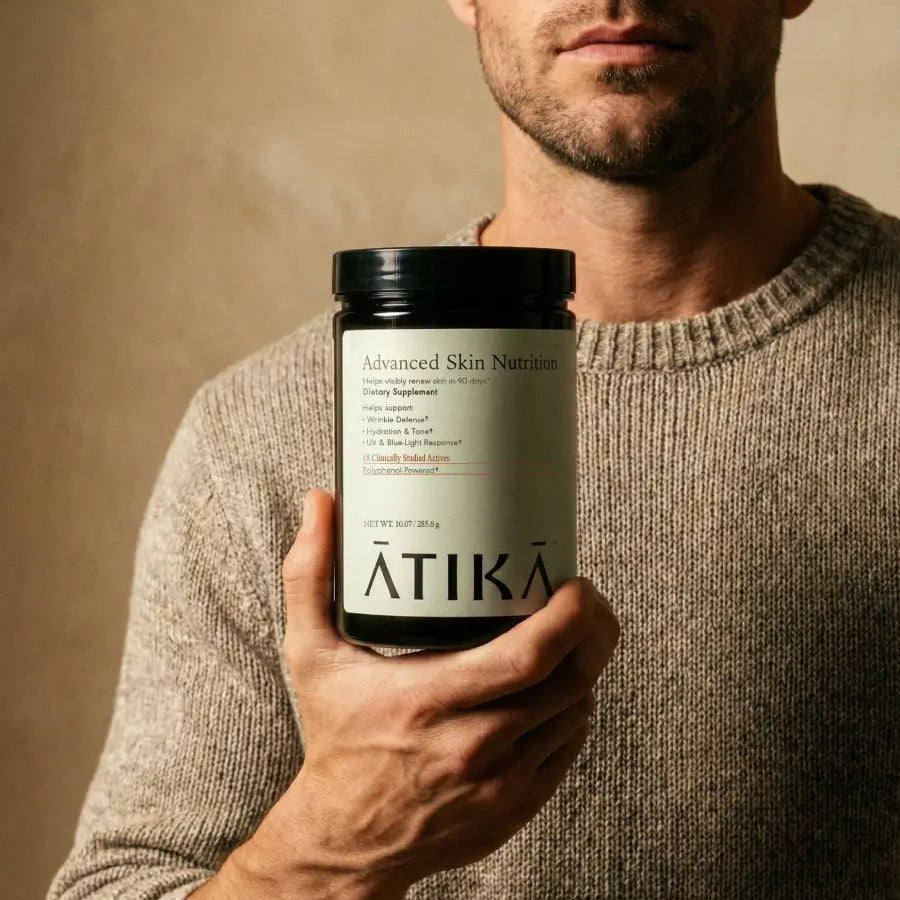 Man holding a supplement container labeled 'Aätika' against a neutral background